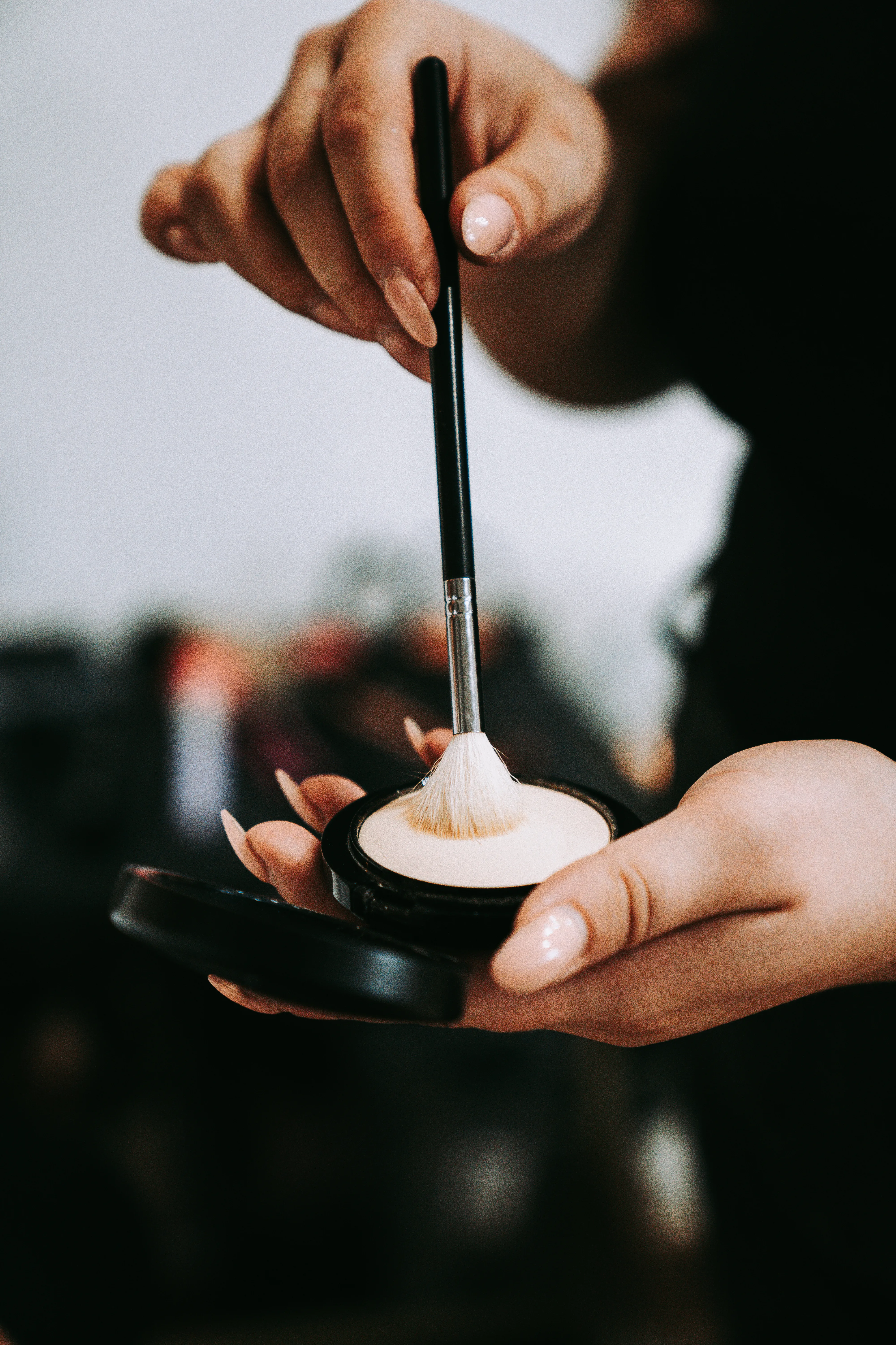 Makeup brush dipping into powder
